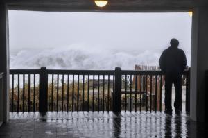 Safe under the cover of the Henlopen Hotel, a man checks out the rough surf. BY NICK ROTH