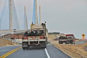 Two tractor-trailers hauling girders arrive early Dec. 18 at the bridge. BY RON MACARTHUR