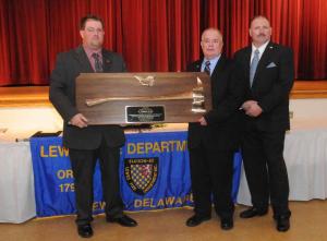 Wally Evans is presented with a ceremonial fire ax for his 38 years of distinguished service. Shown are (l-r) Troy Virden, Evans and Woody Magee. BY STEVEN BILLUPS