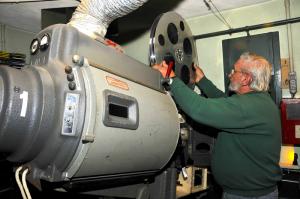 Charlie Thorns places a reel on one of the original 35mm movie projectors. Thorns, who has worked at The Clayton for 29 years, says his favorite movie is "Gone With The Wind." BY RON MACARTHUR
