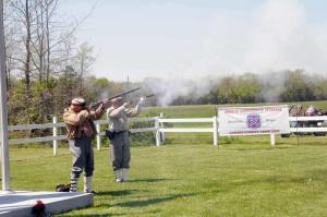 Firing a salute after the raising of the flag are John Zoch Sr., left, and Laurence Ash.
