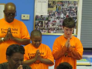 Students at West Side New Beginnings say grace before eating dinner served by Attorney General Joseph "Beau" Biden III. Leading grace is (l-r) program director Diaz Bonville, Phillip Wharton and Kody Crowley. BY RYAN MAVITY