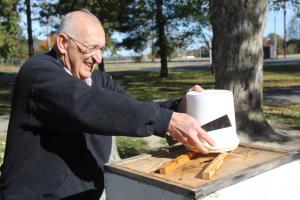 Cash removes sugar water that he fed his bees through the fall. The extra food should help them survive the winter, he says. BY MELISSA STEELE
