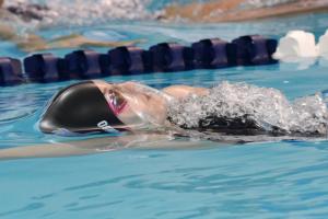 Freshman Sarah Rambo majestically glides through the pool in the 100-meter backstroke. BY DAN COOK