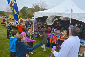 Rehoboth Kite and Toy Company owner Bee Linzey blows bubbles as a crowd tries to pop them. BY RON MACARTHUR