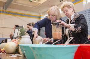 Joyce Lenzo, left, and Carol Aversa prepare juice at the Juice Bar sponsored by Hobos Restaurant in Rehobotth Beach, with proceeds benefitting the Food Bank of Delaware. BY DENY HOWETH
