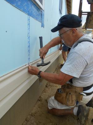 Habitat volunteer Bob Kelly nails up siding on day three of the Home Builders Blitz. SOURCE SUBMITTED