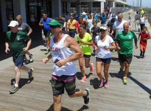 Derek Shockro, Liquid Surf Shop owner and former Rehoboth Beach lifeguard, leads the second wave of runners who gathered to honor Jay Stein. He said he could remember the days he was working the beach and nobody was on the boardwalk because it was so hot, but Jay would out running. BY CHRIS FLOOD