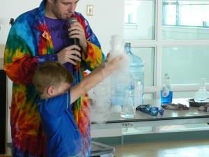 Alexander Undorf, 6, bravely volunteers to hold a beaker overflowing with gaseous dry ice in the beginning of the "Dragons and Dreams" story. Kids learned that dry ice in its gaseous form is safe. BY TAGGART HOUCK