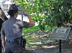 Lewes Sgt. Sherrie Harmon does a slow salute in front of the plaque in honor of Charles Wilson Futcher Sr. BY NICK ROTH