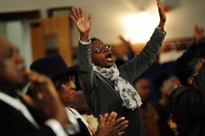 Former Cape assistant principal Janet Maull-Martin praises God during the celebration. BY DAN COOK