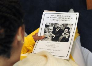 Tiasha Shockley of "We are Praise" looks over the program before her performance. BY DAN COOK