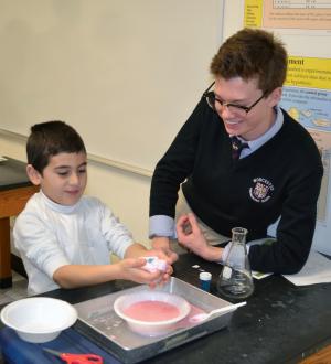 Worcester Prep kindergartner Mario Dahr of Lewes has fun working with sophomore Davis Taylor of Lewes on the super science slime project. SOURCE SUBMITTED