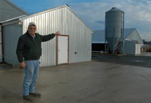 Wesley Clifton points to the last of his three chicken houses, which are about 20 years old but are maintained so they look brand new. BY MADDY LAURIA