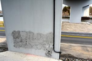 Officials are removing graffiti from underneath the Freeman Highway Bridge. BY RON MACARTHUR