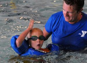 Max Wyshok does his "Jaws" impression during the World's Largest Swimming Lesson as YMCA aquatics director Lydia Schmierer looks on. BY DAN COOK