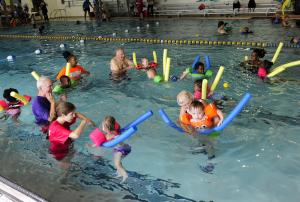YMCA volunteers round up the pool noodle riders during the WLSL. BY DAN COOK