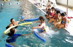 Swimmers learn to jump into the deep end of the YMCA pool while instructors await. BY DAN COOK