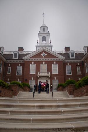 Under stormy skies, an honor guard carries the casket of former Attorney General Beau Biden into Legislative Hall in Dover. BY JOEY MELVIN