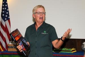 Delaware Seashore Park volunteer coordinator Lee Temby spoke highly of the service that Chuck O'Day provided to the Cape Henlopen State Park. She presented Chuck with Kevin Fleming's book, The Beach. BY DAN COOK