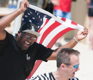 Jermaine Mapp runs with the American Flag. BY DENY HOWETH