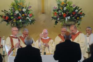 Bishop Francis Malooly breaks the bread of the Eucharist. Shown are (l-r) Deacon Dan Ackerson, the Rev. John Kleevence, Bishop Malooly, the Rev. William Mathesius, the Rev. William Cocco and the Rev. Thomas Peterman. BY STEVEN BILLUPS