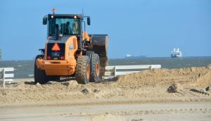 Sand is moved from the parking lot back onto Lewes Beach. BY RON MACARTHUR