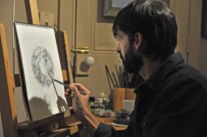 Abraxas Hudson intricately pencils a Christmas wreath in his Second Street studio. BY NICK ROTH