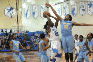 Dover's Thomas Hoskins drives on J.R. Yates. BY DAVE FREDERICK