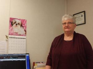 Donna Moore is shown with her shih tzu calendar in the background. BY RYAN MAVITY