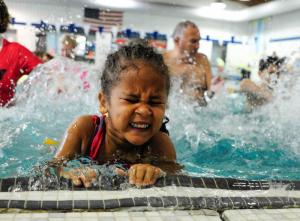 Jeraniah Jackson practices her kicks on the side of the YMCA pool. BY DAN COOK