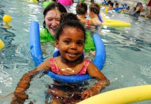 Juelle Finney is all smiles on her pool noodle while volunteer Tracey Condon-Kneifl looks on. BY DAN COOK