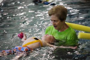 Swimmer Kage Wilke gets floating assistance from volunteer Deborah Minifie. BY DAN COOK