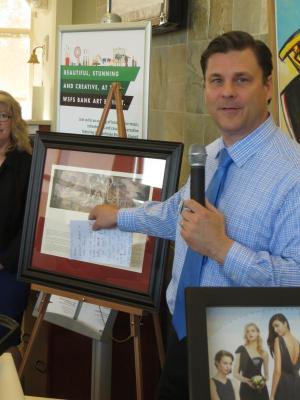 WSFS small business lender Greg Makowsky begins the auction for a print of the NC Wyeth Mural that hung in the old corporate headquarters in Wilmington for decades. BY MOLLY MACMILLAN