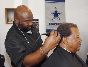 Chester Hope cuts the hair of Ralph Harmon. Hope, a proud Dallas Cowboy fan, makes his allegiance well known. BY NICK ROTH