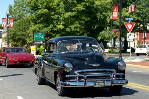 A classic car fills out the parade through town; cars lined up at the school for everyone to attend.
