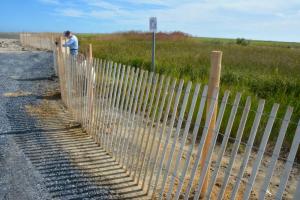 Workers finish a fence leading to Fowler Beach, the public access soon to be opened. RON MACARTHUR PHOTO