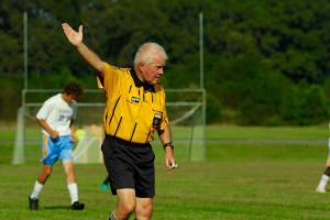 Soccer official makes the “get that beer outta here call.” DAVE FREDERICK PHOTO