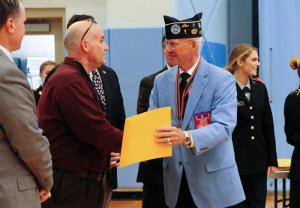 Ed Johnson, right, of Korean War Veterans Association is congratulated by Cape Principal Brian Donahue. DAN COOK PHOTO