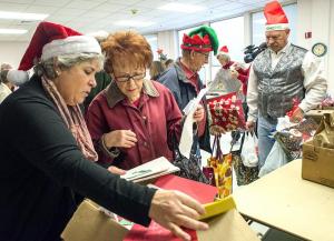 Julia Bock (l-r) helps Marie Evick choose a card while Sheriff Robert Lee helps Don Evick with his packages.