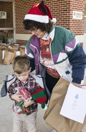 Joan Moyer helps Evan Moyer who is learning how to give back; this is his first year on the Christmas route.