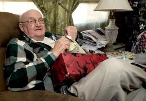 Fred Reed unwraps a gift of house shoes that he said he can really use, since he gets chilly in winter.