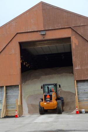A DelDOT front-end loader is dwarfed by a large mountain of salt stored in a barn for use this winter. RON MACARTHUR PHOTO