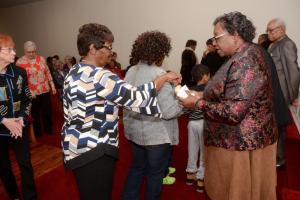 Service attendees come to the altar to take part in the Eucharistic meal.