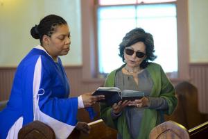 Tiasha Shockley shares a hymnal with Charito Calvachi-Mateyko.