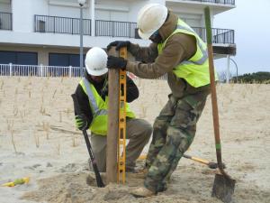 Tamba Solee and Jose Armondo get the first post of the new dune fencing in place. CHRIS FLOOD PHOTO