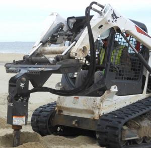 Charlie Black uses a Bobcat to drill a post hole. Each post is 8 feet long, with four of those feet sticking out. CHRIS FLOOD PHOTO