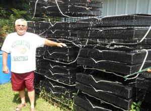 Steve Friend of Georgetown stands next to a few dozen cages he's made in anticipation of receiving a permit in this 2014 photo. CHRIS FLOOD PHOTO