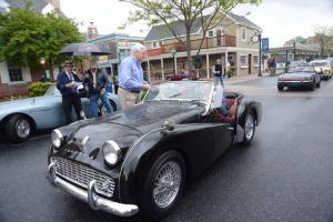 Under rainy skies, Mayor Ted Becker hands the Best In Show to Dennis Morrison in his 1960 Triumph TR3A, as show chair Mike Tyler reads off the name. British Car Show