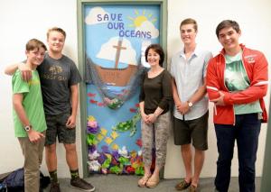 Upper school students stop by to see Environmental Club faculty advisor and teacher Kathleen Otway's homeroom door which won Honorable Mention. Shown are (l-r) Dakin Moore of Rehoboth Beach, Michael Curtis of Bethany Beach, Kathleen Otway, Brenner Maull of Salisbury, Md., and Dominic Anthony of Seaford. SUBMITTED PHOTO